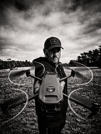 Sean Dewil, BlueCurve founder, holding a drone in the field